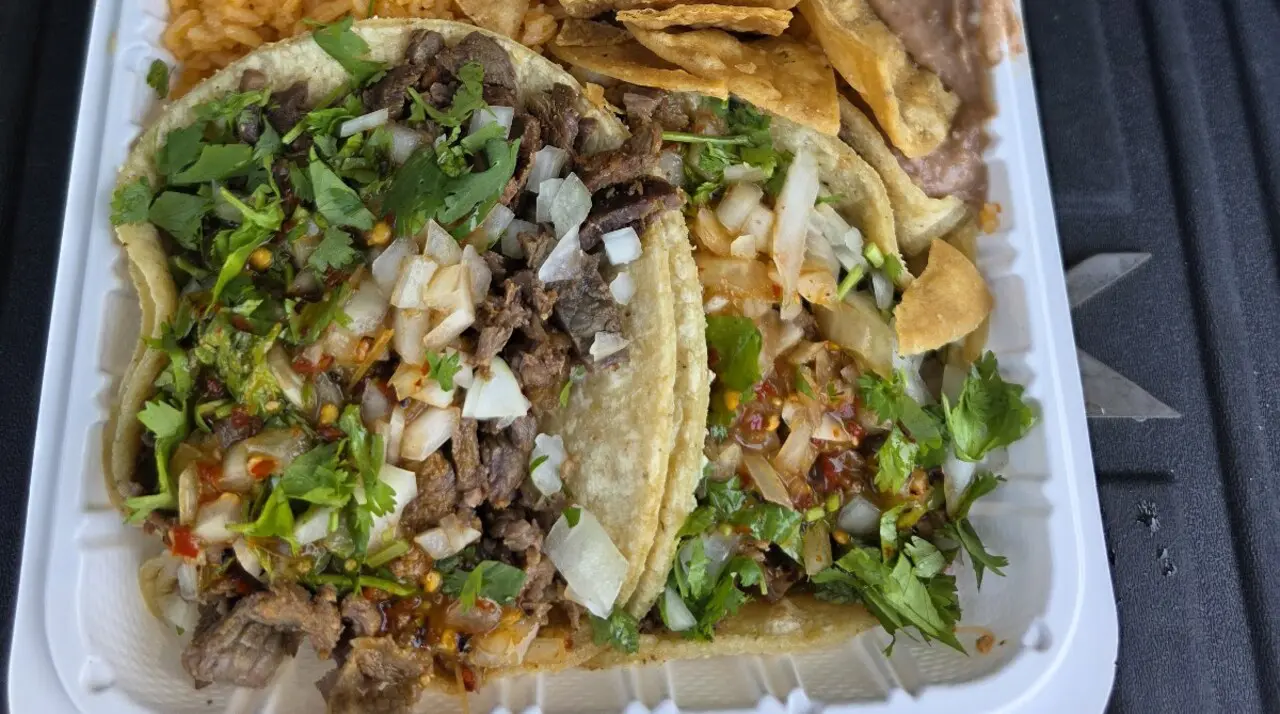 Carne asada taco combo from El Toro Bravo Tortilleria in Costa Mesa: three street tacos with onion, cilantro, salsa, plus rice, beans, and house chips