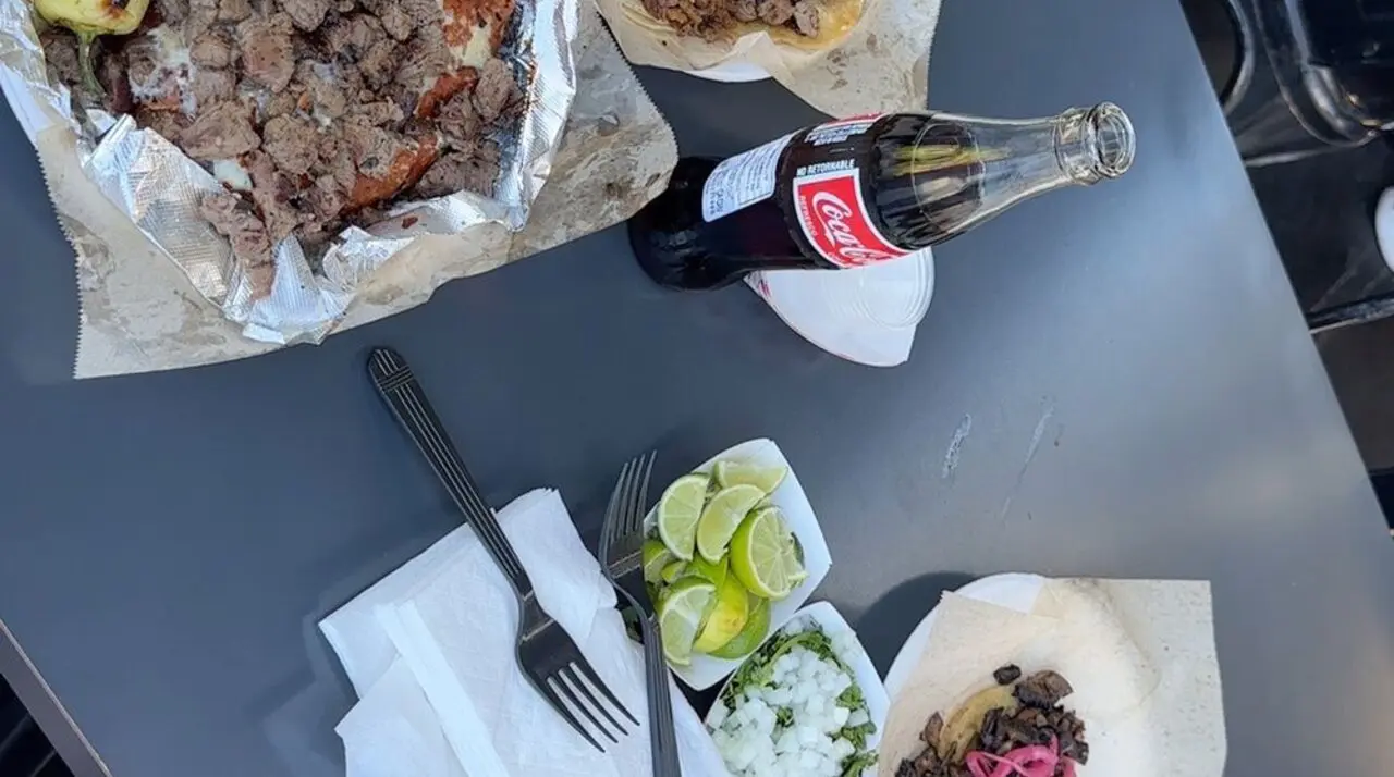 Carne asada tacos from Tacos Los Cholos in Anaheim, piled with chopped mesquite-grilled steak and a charred yellow chili