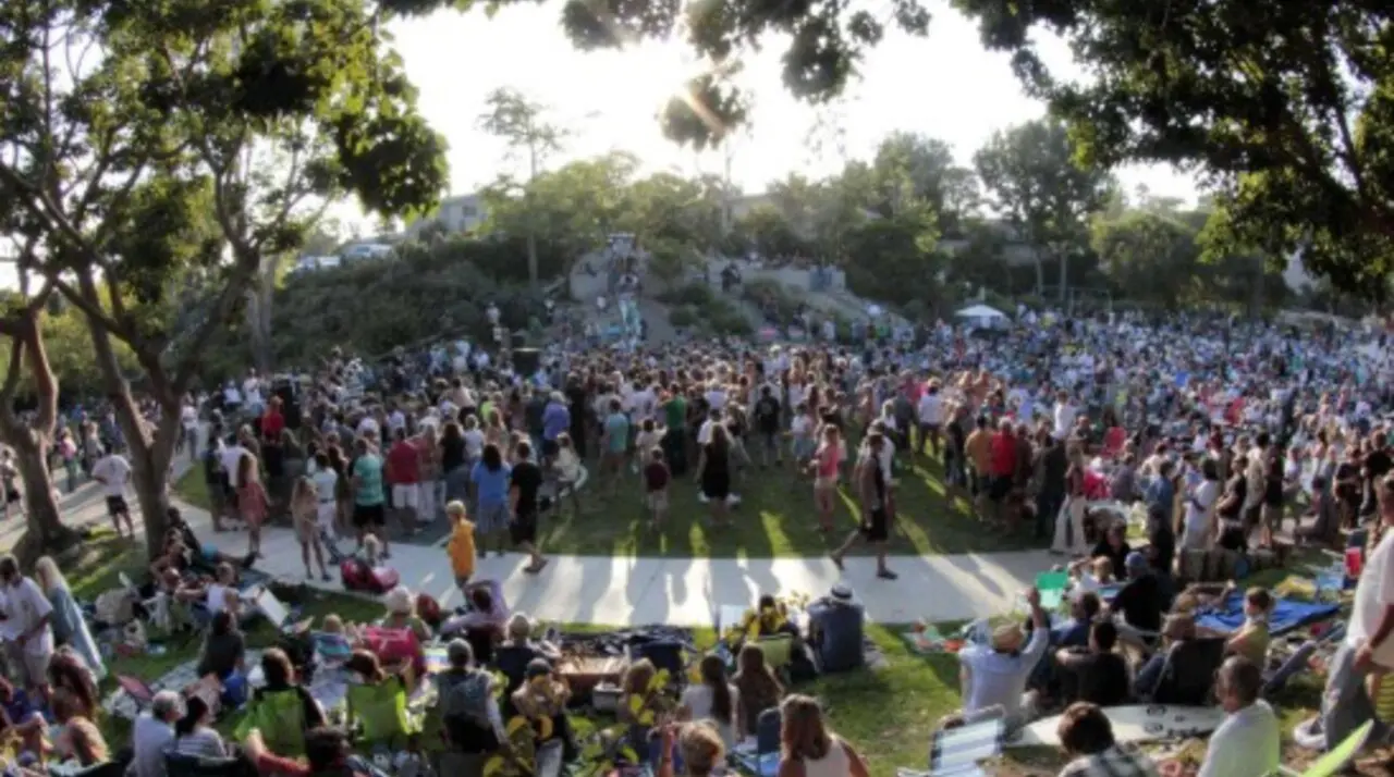 Crowd on blankets and lawn chairs at a free Music in the Park concert in Laguna Beach